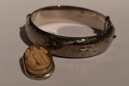 A conche shell cameo brooch/pendant depicting the three Graces in a plain white metal mount