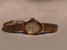 A lady's 9ct gold Rotary wrist watch having baton numeral dial to oval face on a graduated 9ct