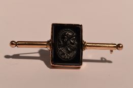 A rose gold bar brooch having a rectangular onyx intaglio panel to centre depicting a centurian,