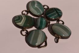 A green stripe agate bracelet having five oval panels in white metal mounts with chain links, no