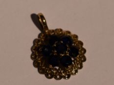 A 9ct gold pendant having a sapphire cluster in an openwork circular mount, no chain, approx 1.6g