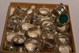A selection of white metal dress rings of various designs including enamelled and elephant, most