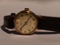 A lady's 9ct gold wrist watch having an Arabic numeral dial to champagne face in a gold case on a