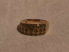 A lady's band ring having a triple row of alexandrite in a chequered mount on a 9ct gold loop,