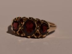 A lady's dress ring having a trio of garnets interspersed by garnet chips in a gallery mount on a