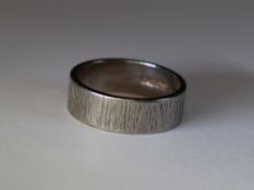 An 18ct white gold wedding band having bark effect decoration, size L & 6g
