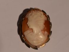 A conch shell cameo brooch depicting a maiden in profile in a decorative 9ct gold mount, approx 7.