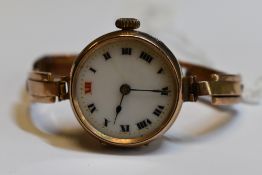 A lady's vintage 9ct gold wrist watch having a Roman numeral and gilt dot dial to circular face in a
