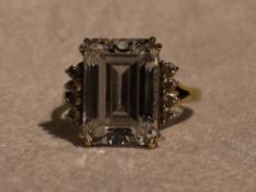 A lady's dress ring having a baguette cut cubic zirconia flanked by two rows of four round cut CZ to
