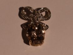 A morganite style oval pendant in a claw set mount with a diamond chip set bow loop, with Gems TV