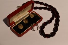 A cased set of three 9ct gold collar studs bearing monograms, a damaged white metal band ring with