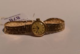 A lady's 9ct gold Omega wrist watch having a baton numeral dial to champagne face in a gold case