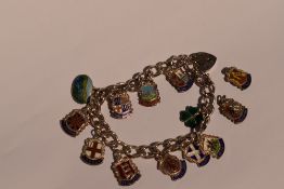 A silver bracelet with padlock clasp having eleven (& two loose) white metal shields stamped silver,
