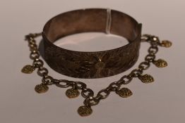A 1970's silver hinged bangle having engraved floral decoration and twist clip clasp and a silver