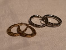 A pair of 9ct white gold hoop earrings having pink paste and cubic zirconia decoration and a pair of