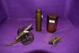 A quirky collection consisting of a brass cannon and similar wooden and brass one,a shell case and a