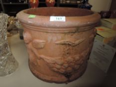 A terracotta plant pot having cherub design.
