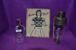 A vintage cocktail shaker, glass bottle with metal and cork stopper and a vintage style