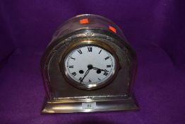 A vintage plated mantle clock of arched form with German movement.