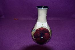 A small baluster shaped Moorcroft vase having pansy design.