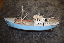 A wooden hand built model steam boat numbered 476, painted in blue and white with brown hull