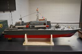 A wooden hand built model radio controlled military boat, painted in grey and with red hull having