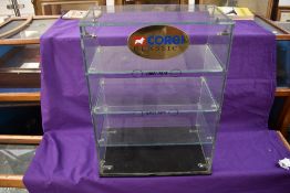 A Corgi Toys glass shop display case having three glass shelves with oval Corgi Classics plaque,