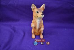 A composition Corgi shop advertising dog and four advertising enamel badges, Corgi, Dinky and Spot