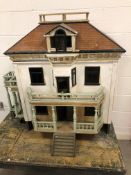 A Victorian painted pine two storey Dolls House having opening front and roof with balustrade