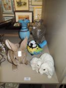two resin rabbits, a blue tit wind chime and two glass vases.