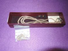 A Faux pearl necklace and a yellow metal chain.