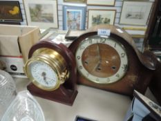 A vintage mantel clock and another in the shape of portal.