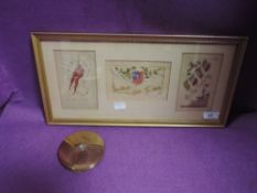 A framed selection of embroidered sweetheart postcards and a vintage compact.