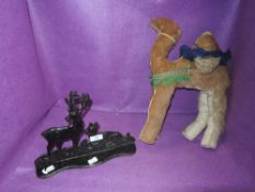 A cast iron door stop depicting two deer and an ornamental stuffed camel.