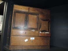 A vintage wooden cabinet with draws of varying sizes and a miniature cupboard housing a selection of