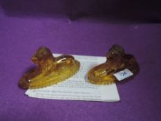 Two amber press moulded glass lion paperweights.AF