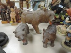 Three friendly looking carved wooden bears, in a black forest style, and similar wooden carved
