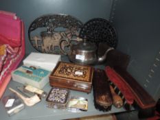 A miscellany of vintage items amongst which are a selection of brushes, trivets, clay pipe,
