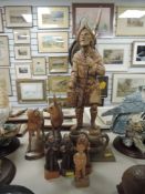 A selection of wooden items including a carved figure of a European gate keeper, three intoxicated