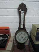 A vintage wooden cased barometer having white glass face dial