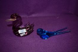 A blue glass swallow and a amethyst tinted swan.