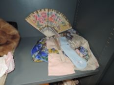 Two vintage paper fans an apron a set of gloves and similar.