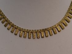 A 9ct gold collarette of graduated articulated form having a concealed clasp and brush effect