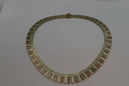 A 1970's 9ct rose and yellow gold collarette of graduated articulated form having brush effect