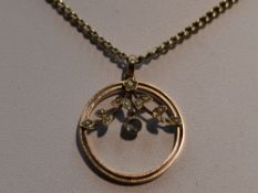 An Edwardian yellow metal pendant stamped 9ct of circular form having seed pearl decoration with