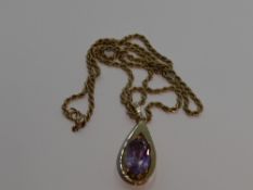 A large amethyst pendant in a yellow metal tear drop shaped open mount stamped 9ct on a 9ct gold