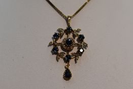 An Edwardian style 9ct gold pendant having central sapphire and diamond cluster in a diamond and