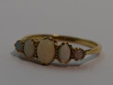 A lady's dress ring having five graduated oval opal cabouchons in a claw set gallery mount on a