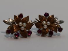 A pair of 9ct white and yellow gold stud earrings modelled as leaves having ruby and seed pearl