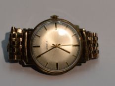 A gents 9ct gold wrist watch by Mondia having a baton numeral dial to silvered face in a 9ct gold